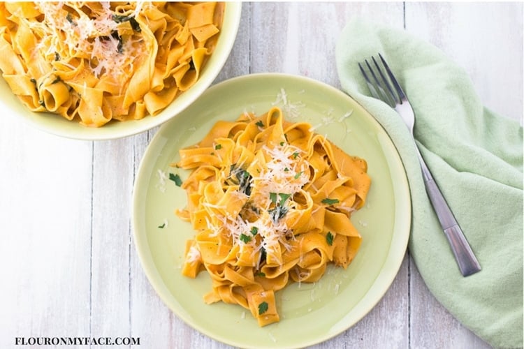 one pot Vegetarian Pappardelle recipe on a green plate, a serving bowl of the meal with a green napkin and fork.
