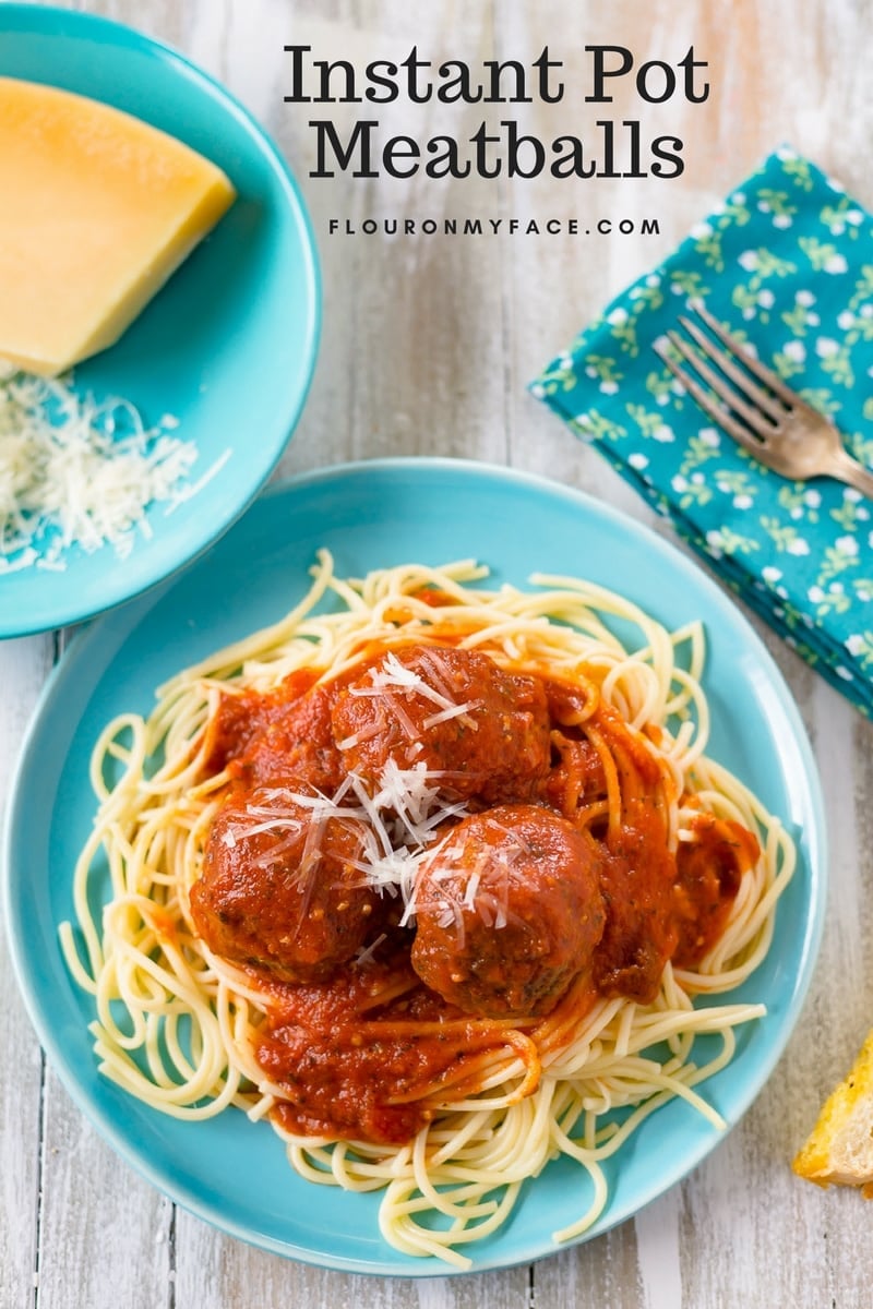 Instant Pot Meatballs served on a teal colored vintage plate on a bed of spaghetti pasta