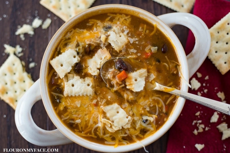 Crock Pot Pumpkin Turkey Chili recipe served with sour cream, shredded cheddar cheese and saltine crackers.
