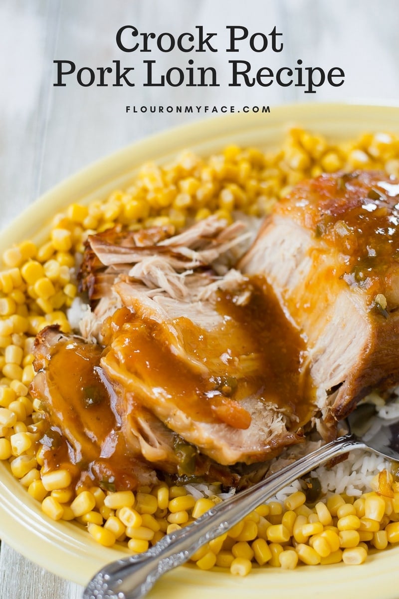 Crock Pot Pork Loin recipe made with apricot glaze served on a yellow Fiestaware platter with rice and corn.