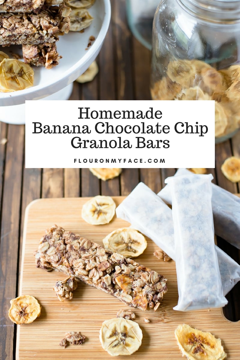 Homemade Banana Chocolate Chip Granola Bars wrapped in parchment paper on a wooden cutting board.
