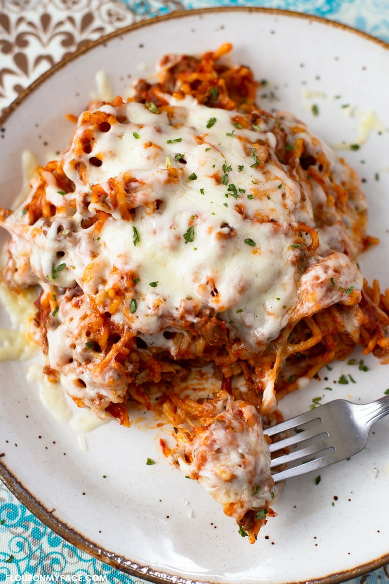 Cheesy spaghetti recipe made in the crock pot served on a white plate