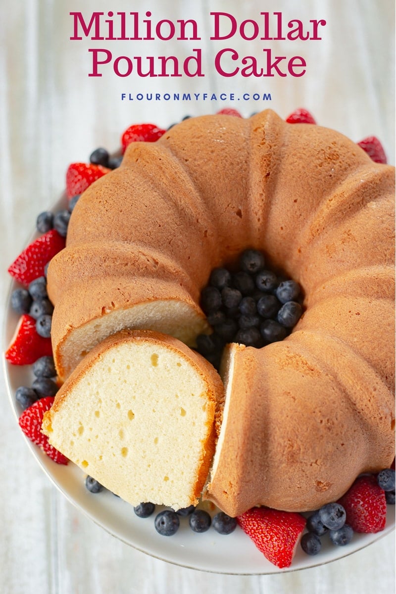 Million Dollar Pound Cake recipe served on a cake platter with fresh berries.