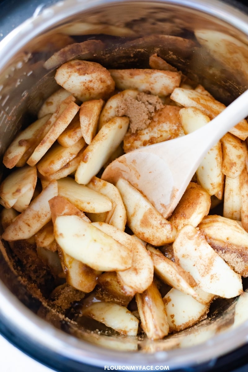 Instant Pot Cinnamon Apples ingredients mixed in with sliced apples before cooking.