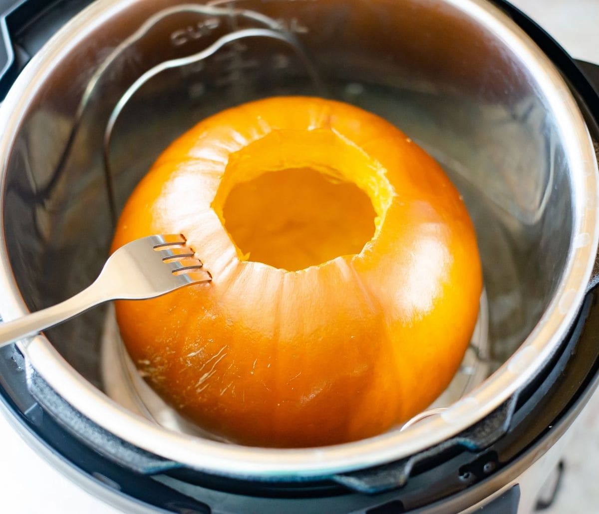 Piercing a pumpkin with a fork to see if it is cooked.