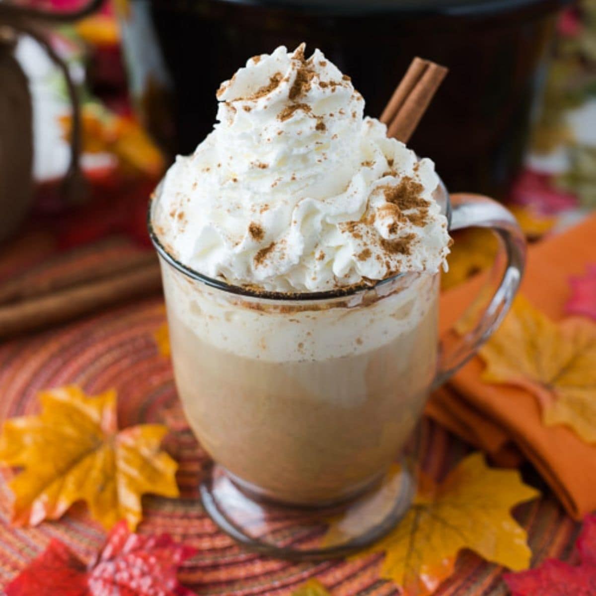 A mug filled with Pumpkin Spice Rumchata Latter on a Fall decorated tables top.