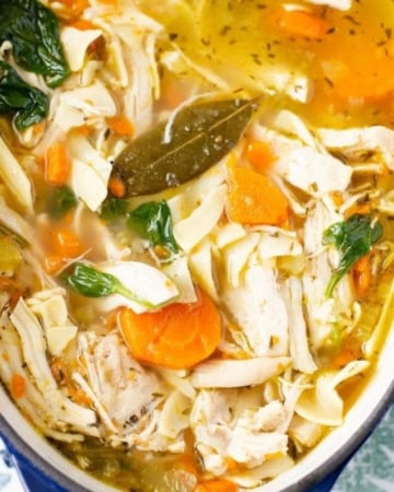 Serving chicken noodle soup from a cast iron pot.