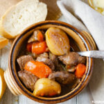 A brown pottery bowl of Hearty Beef Stew