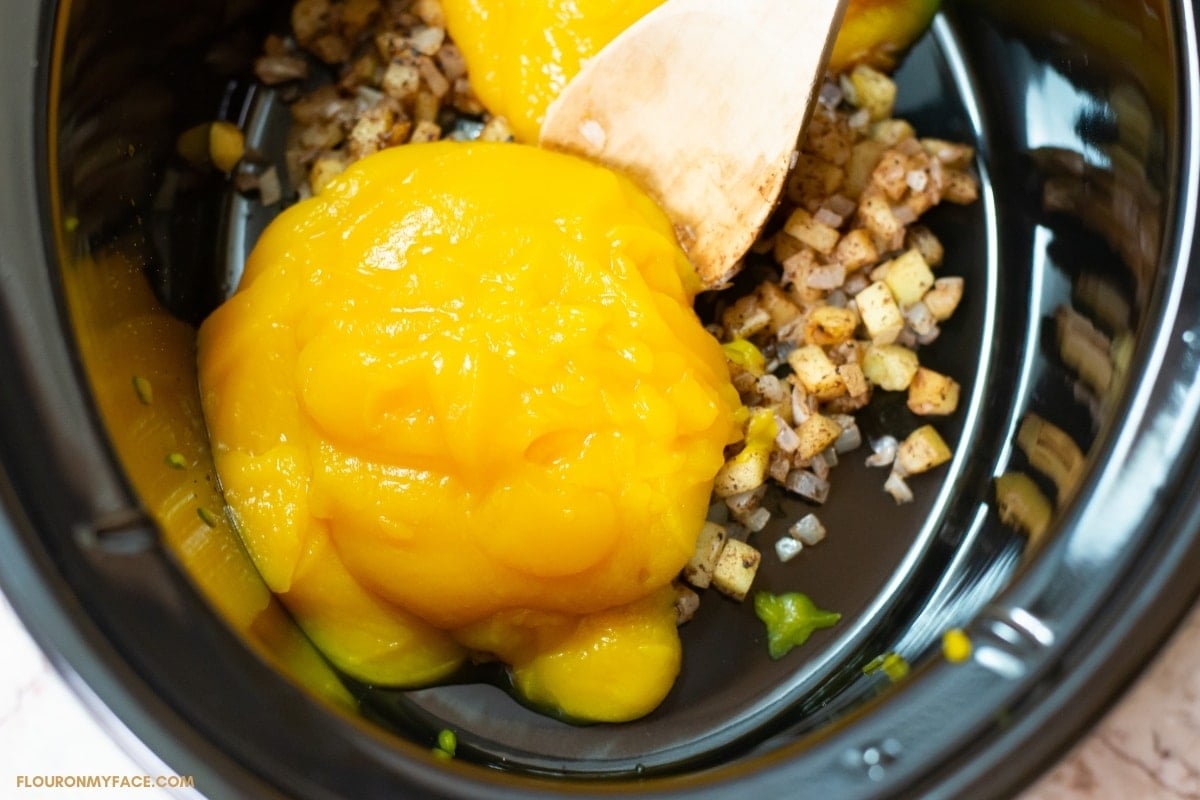 Pure pumpkin puree in a crock pot with other ingredients