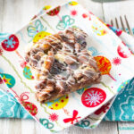 A square of Cranberry Pecan Dessert Bars on a vintage style dessert plate with a teal cloth napkin