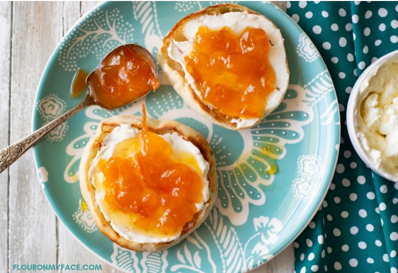 Homemade Peach Orange Marmalade recipe spread over a toasted English Muffin with cream cheese