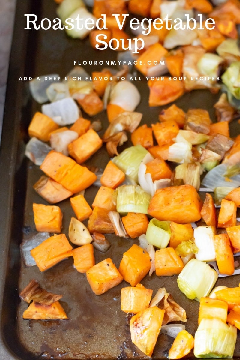 A baking tray full of roasted sweet potatoes, leeks, onion and garlic.