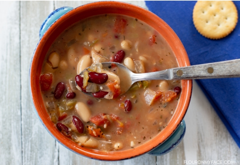 A bowl and spoon with Crock Pot Spicy Bean Soup recipe