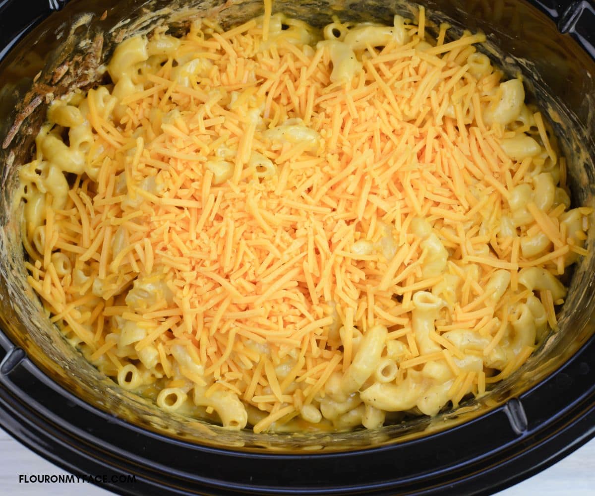 Elbow macaroni, cubed Velveeta cheese and shredded sharp cheddar added to elbow pasta in a crock pot.