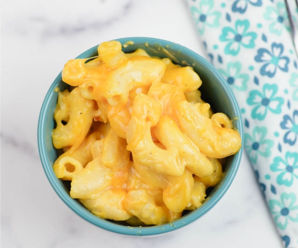 A small single serve bowl filled with cheesy mac and cheese.