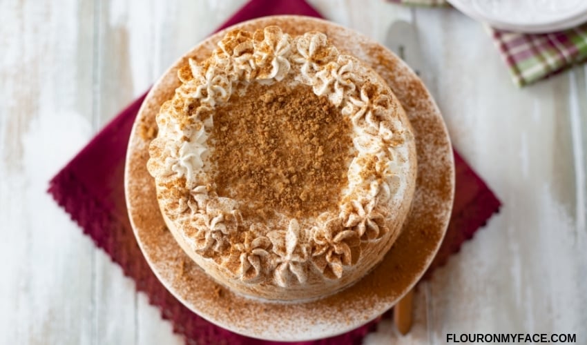 Decorate the top of a holiday cheesecake with cookie crumbs and a dusting of ground cinnamon