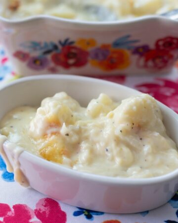 A small oval dish filled with cheesy Gouda Cauliflower Casserole.