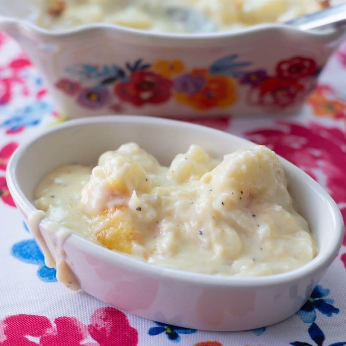 A small oval dish filled with cheesy Gouda Cauliflower Casserole.