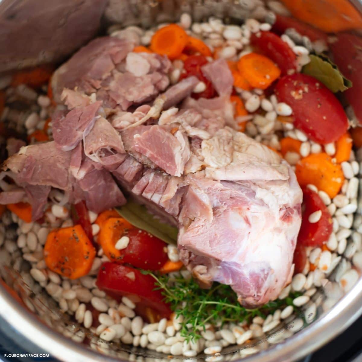 Overhead image of ham and beans soup ingredients in the pressure cooker.