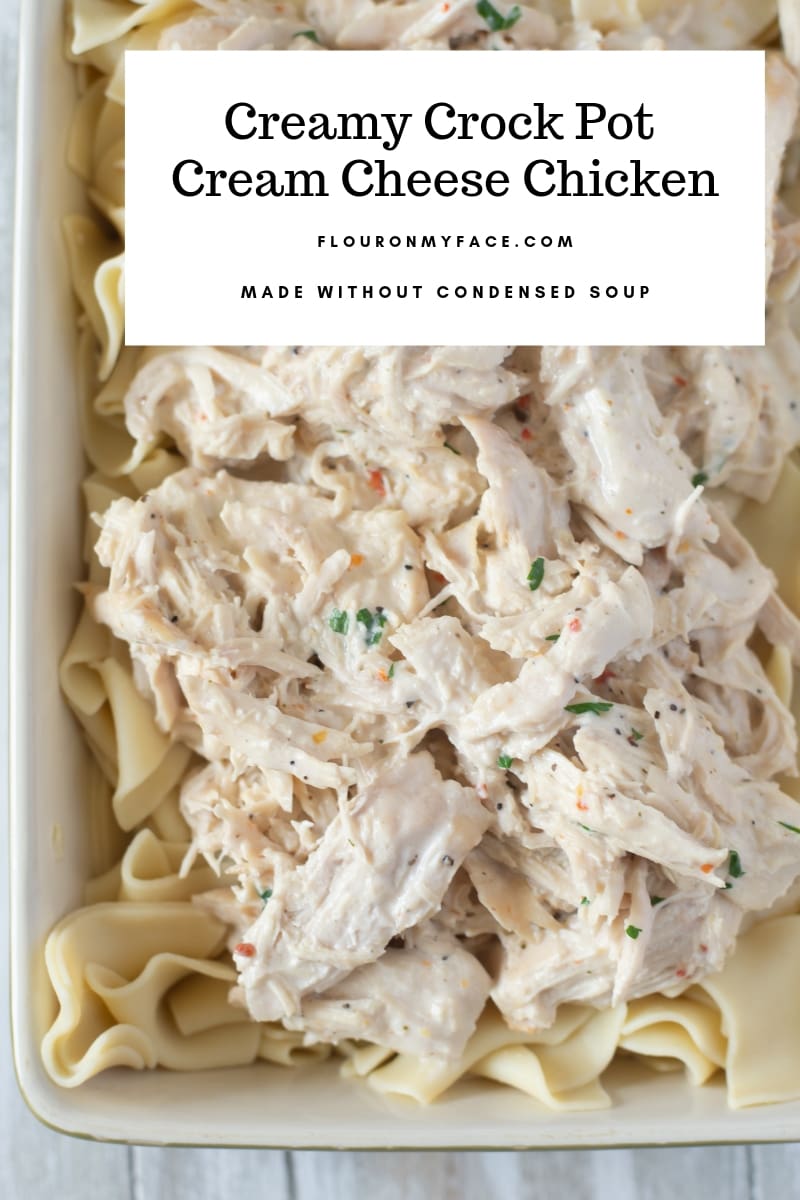 Crock Pot Cream Cheese Chicken recipe served over noodles in a green baking pan