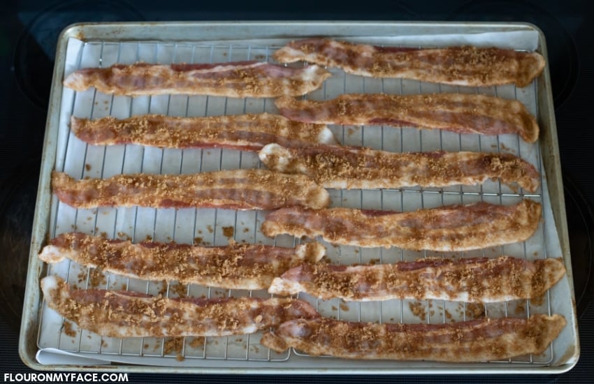 Bacon slices covered with brown sugar on a baking tray