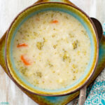 A brown and teal bowl filled with Instant Pot Cauliflower Broccoli Soup