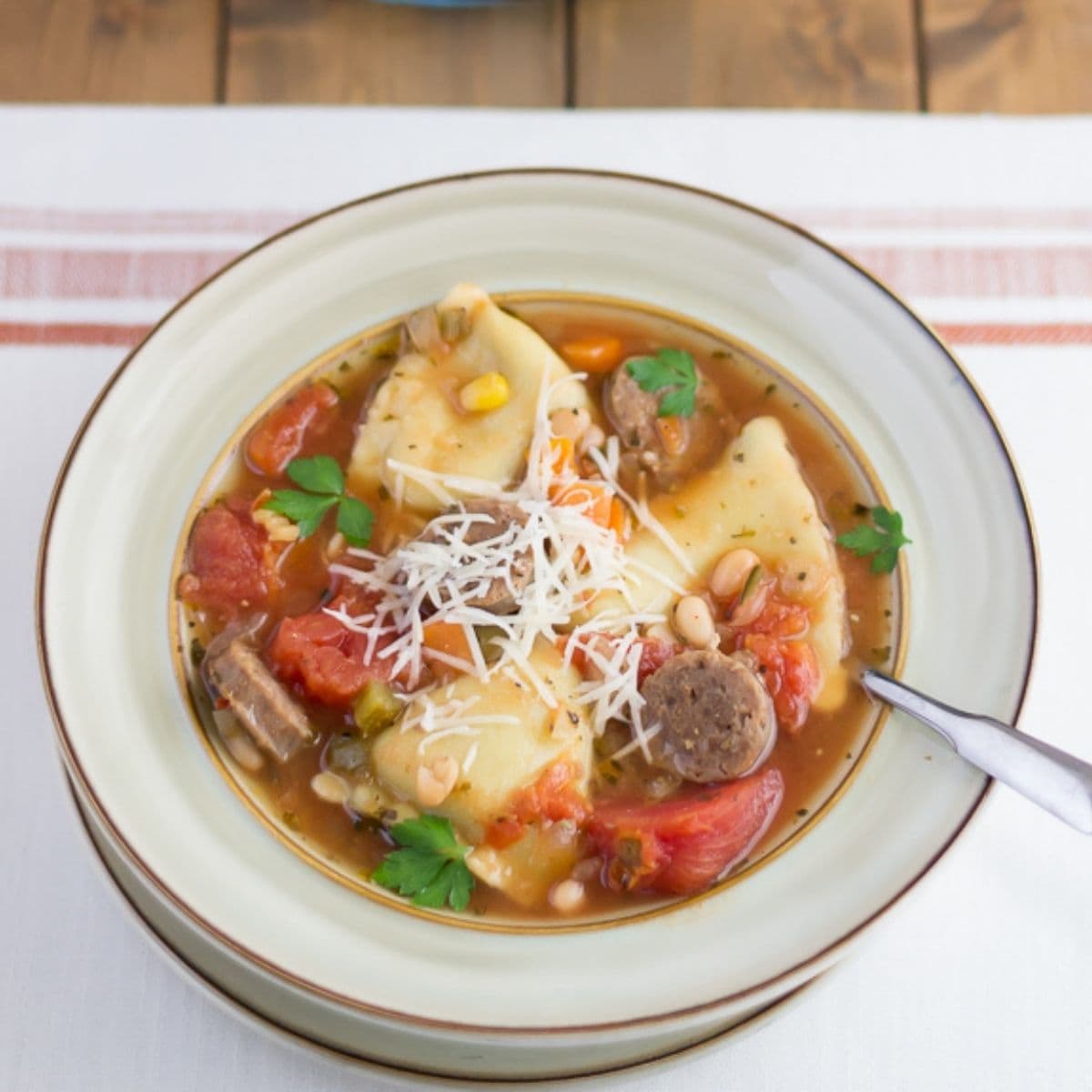 Soup bowl filled with Italian Sausage and cheese ravioli soup.