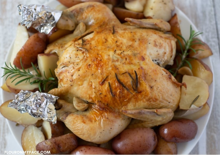 Crock Pot Rosemary Chicken made with a whole chicken served over red potatoes on a platter