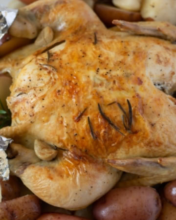 Crock Pot Rosemary Chicken made with a whole chicken served over red potatoes on a platter