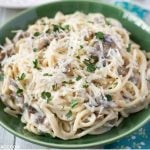 close up photo of a green vintage bowl filled with Crock Pot Chicken Tetrazzini garnished with shredded Parmesan cheese and fresh parsley