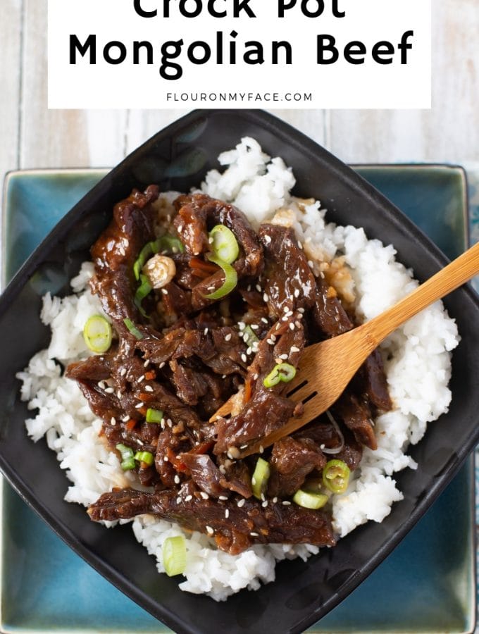 a black and turquios bowl filled white cooked white rice and tender Crock Pot Mongolian Beef