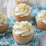4 homemade vanilla cupcakes frosted with homemade Swiss meringue buttercream frosting with sprinkles.