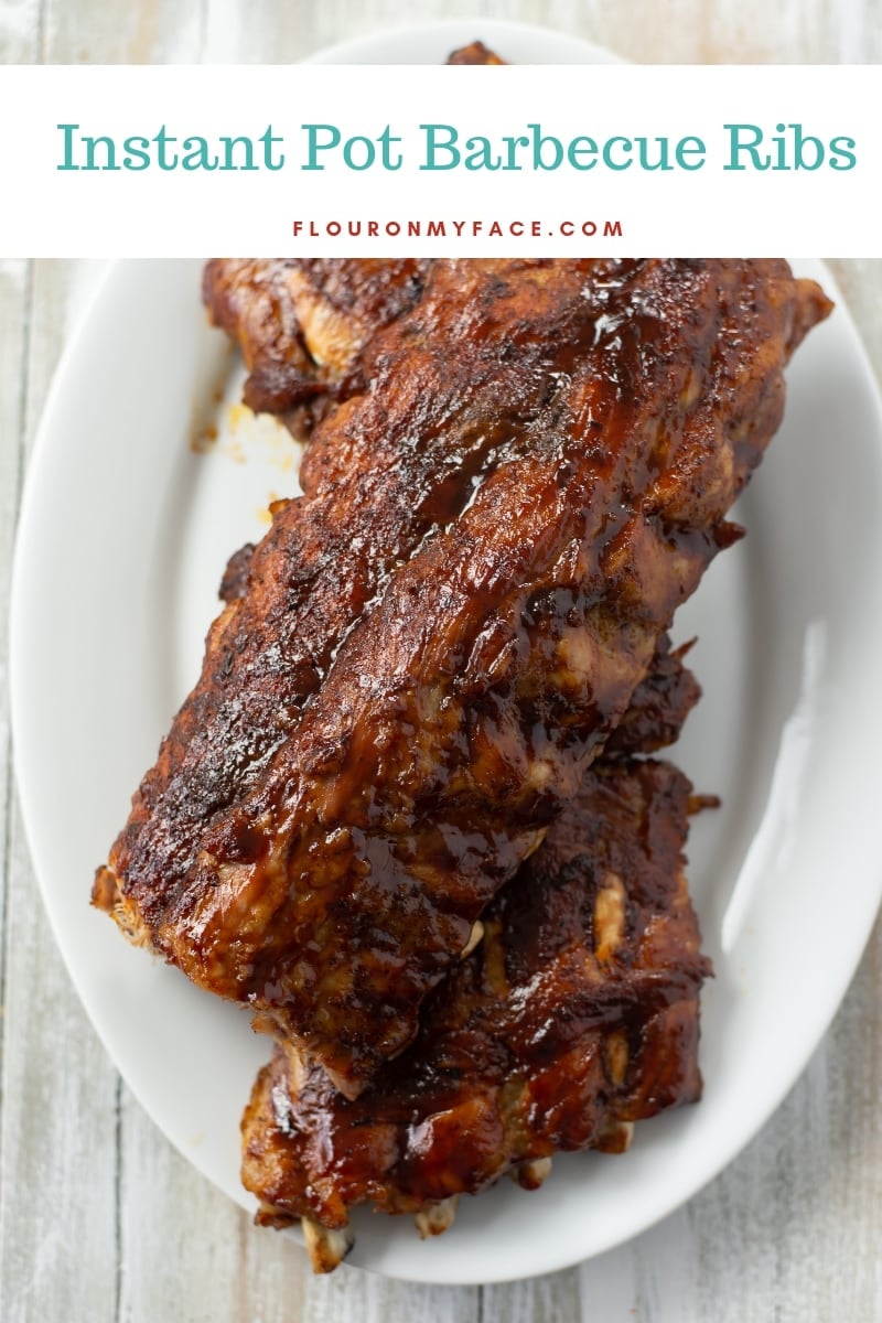 Two racks of barbecue baby back ribs that have been pressure cooked in the Instant Pot and served on a large platter