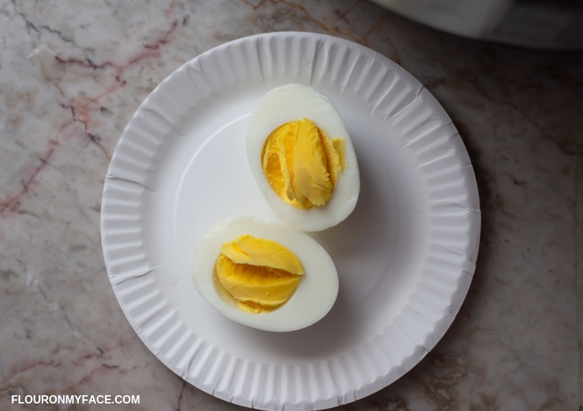 a picture of a hard boiled egg that has been cooked in the instant pot and cut in half showing the cooked yolk.