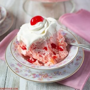 Pink Salad recipe made with maraschino cherries topped with Cool Whip and served on a vintage floral dessert dish.