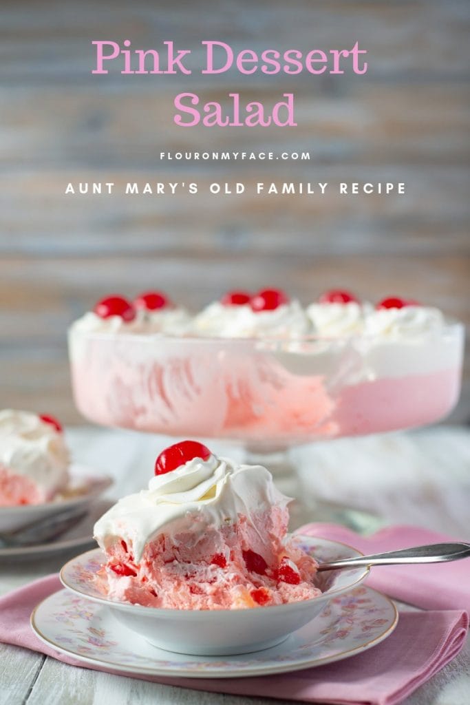 Two servings of Pink Salad on vintage dessert plates with a trifle bowl of the layered pink and white ingredients.