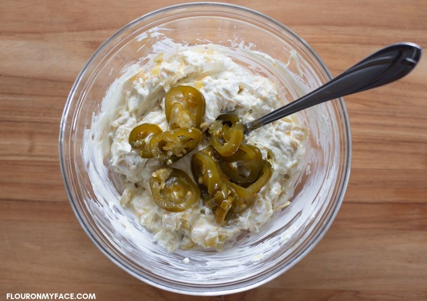 A glass bowl filled with jalapeno popper filling.