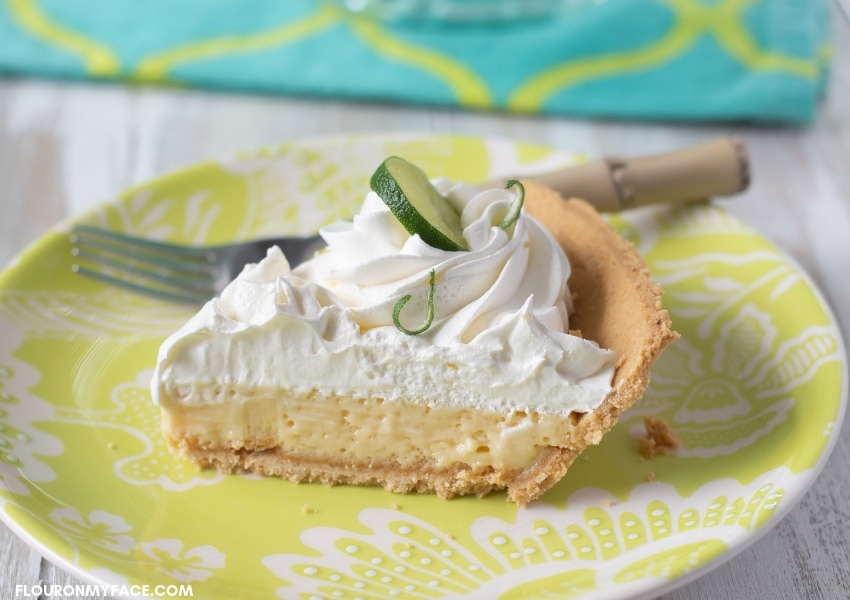 A photo of a sliced piece of Authentic Key Lime Pie on a plate.
