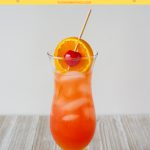 The Classic Hurricane Cocktail served in a tall hurricane glass with a orange slice and maraschino cherry garnish.