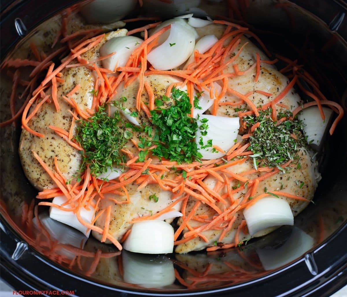Overhead photo of the creamy chicken ingredients layered inside the crock pot.