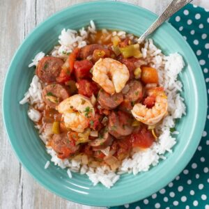 A teal bowl filled with Shrimp Sausage Jambalaya over white rice.