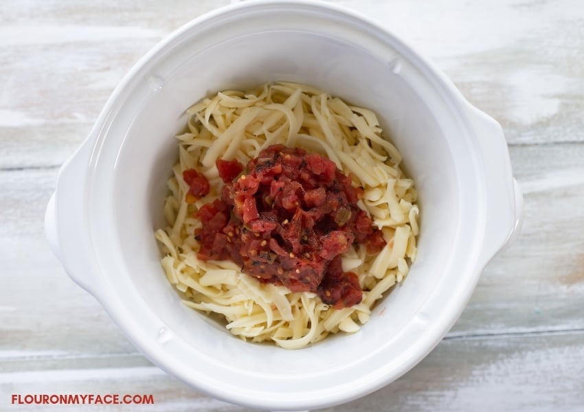 a 2.5-quart crock pot with shredded cheese and Rotel Tomatoes