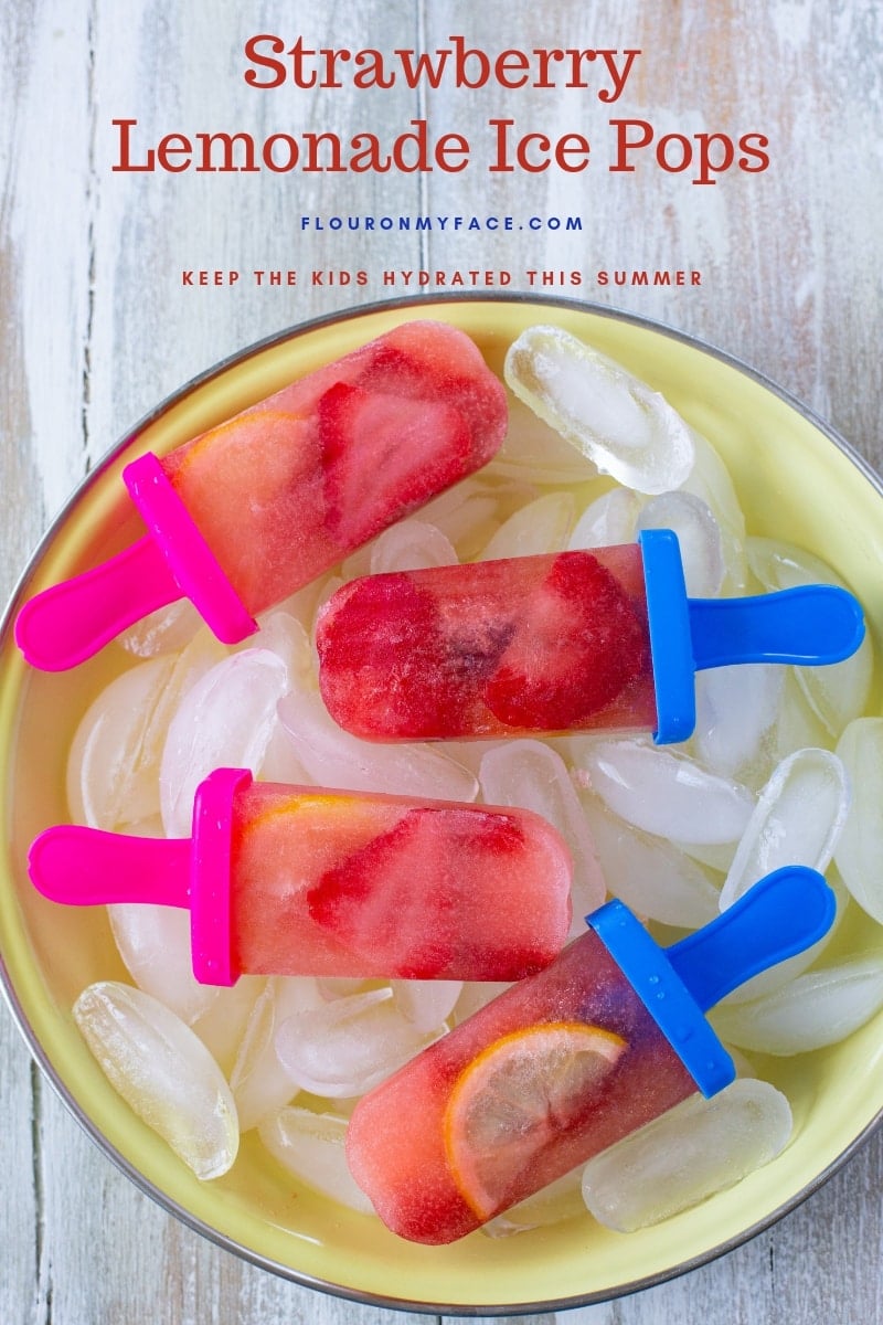 Homemade Strawberry Lemonade Ice Pops on a bed of ice cubes to keep this kid friendly frozen treat chilled