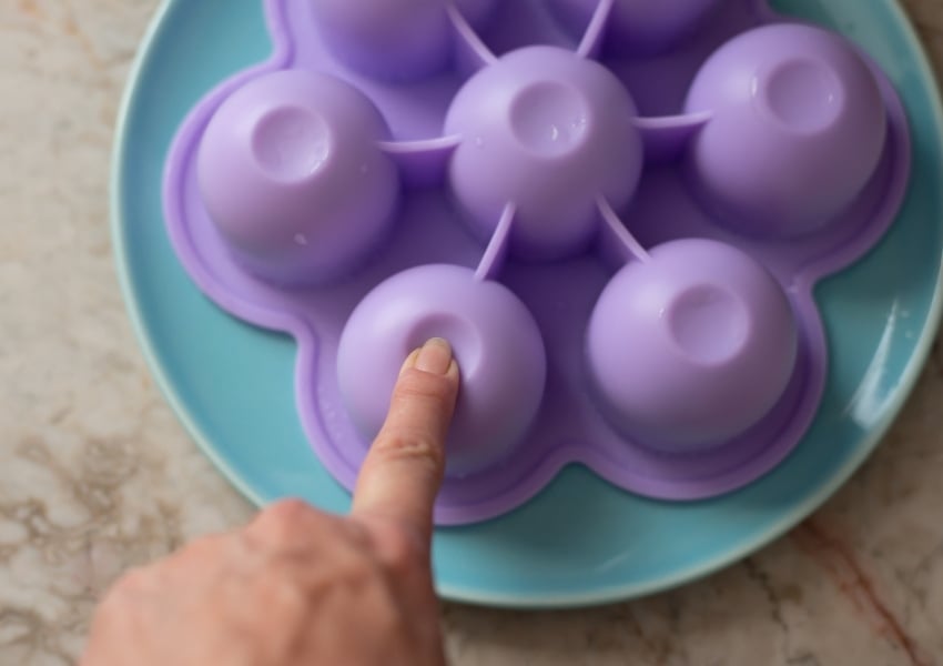 How to press and release blueberry muffin bites from a silicone egg bites mold.
