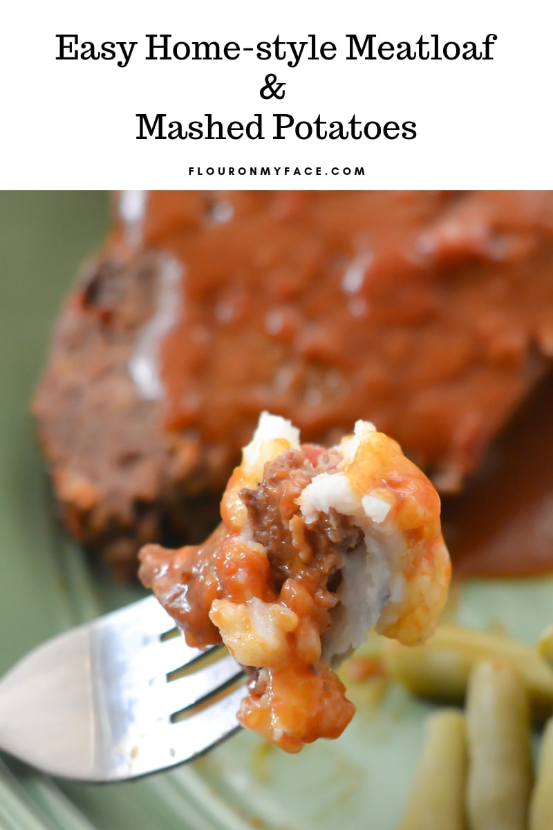 A close up photo of a bite of Crock Pot Meatloaf on a fork dipped in mashed potatoes.