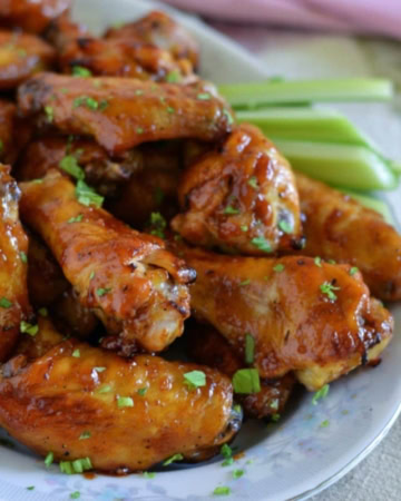 Honey BBQ Chicken Wings on a serving platter with celery and ranch dressing.