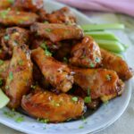Honey BBQ Chicken Wings on a serving platter with celery and ranch dressing.