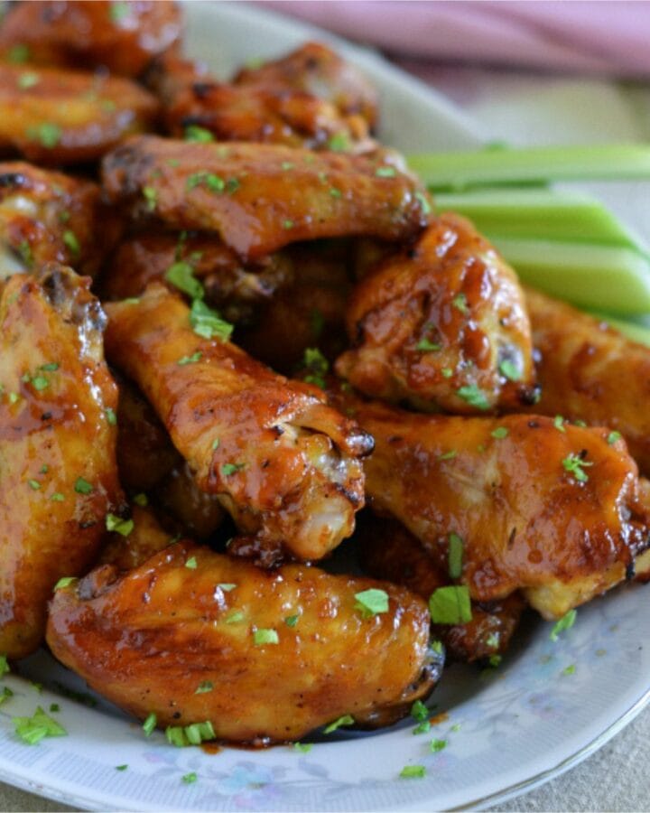 Honey BBQ Chicken Wings on a serving platter with celery and ranch dressing.