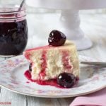 Sweet Cherry Preserves served over a slice of cheesecake with a jar of the preserves in the background