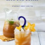 A mason jar glass filled with Carambola iced tea recipe with sliced starfruit and mint garnish. The filled glass pitcher is in the background.